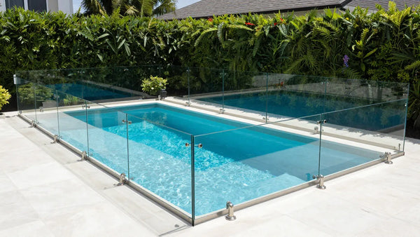 Glass fence surrounding residential swimming pool for safety