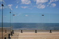 displays a frameless glass railing system with spigot mounts
